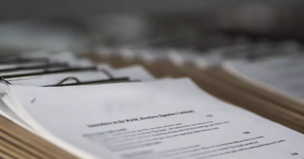 Foto de um bloco de papéis com coisas escritas representando os documentos e informações necessárias para solicitar uma cotação de plano de saúde.