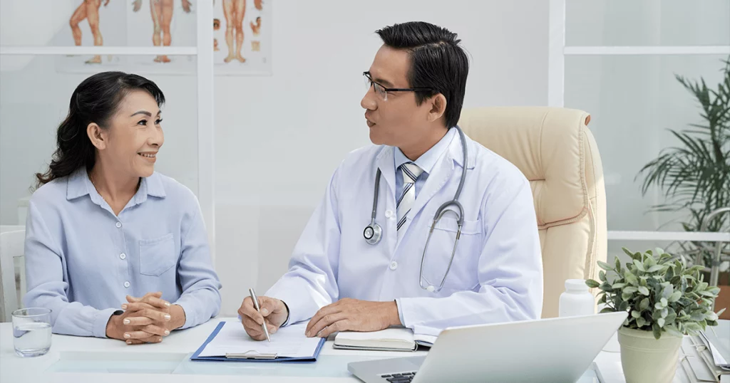Doutor e paciente conversando em um consultório representando uma consulta de um plano de saúde empresarial