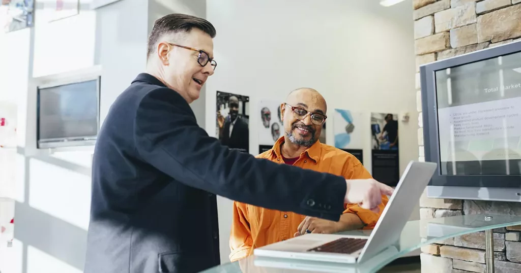 Dois homens representando que o investimento em uma equipe de vendas gera resultados financeiros.